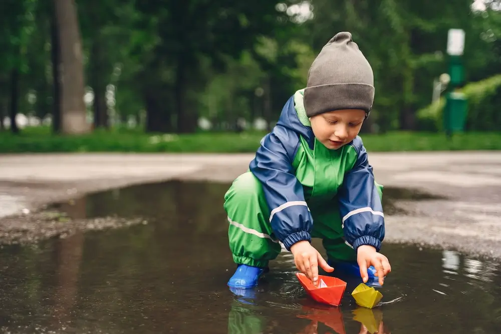 funny-kid-rain-boots-playing-rain-park.webp